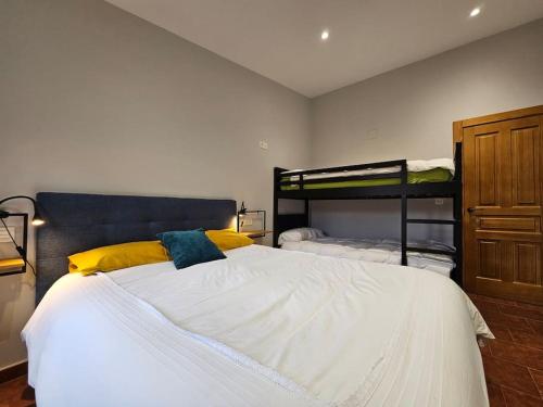 a bedroom with a large white bed with yellow pillows at 10A04 Casa Petacos in Pravia