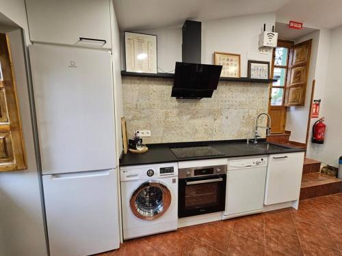 a kitchen with a washing machine and a refrigerator at 10A04 Casa Petacos in Pravia