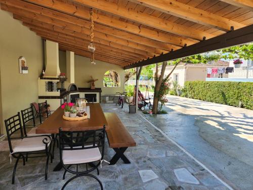 un patio con pérgola de madera, mesa y sillas en The family's house, en Tríkala