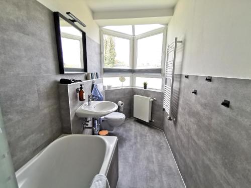 a bathroom with a tub sink and a toilet at BohnApartments EGA Stadtblick - Garten - WLAN - Nähe Theater EGA und Messe in Erfurt