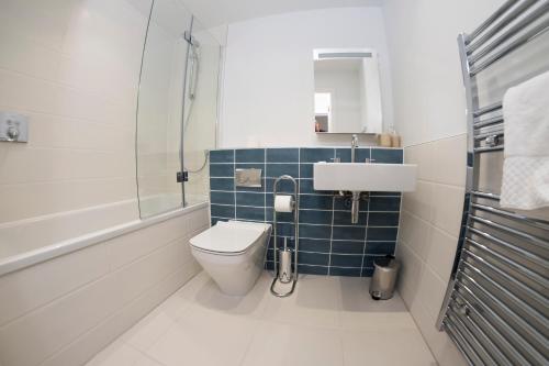 a bathroom with a toilet and a sink at 7 Putsborough - Luxury Apartment at Byron Woolacombe, only 4 minute walk to Woolacombe Beach! in Woolacombe