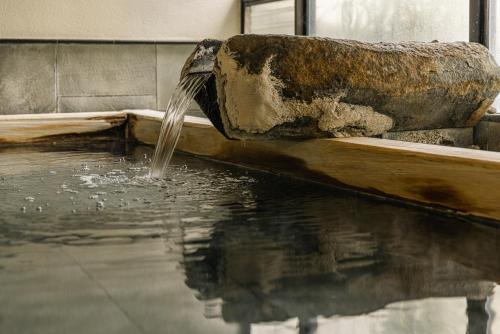 a water fountain in a pool of water at Atarayo Nishiizu Onsen in Izu