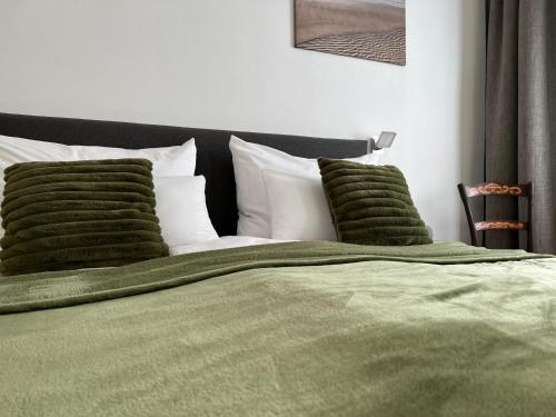 黑馬戈爾的住宿－das STOCKSTAN，一张带绿毛毯和枕头的床