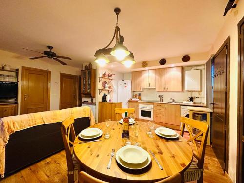 a kitchen with a wooden table with chairs and a dining room at Apartamento Alberto in Margudgued
