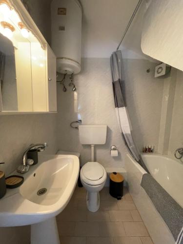 een badkamer met een toilet, een wastafel en een bad bij Maisonette by the sea in Keramotí