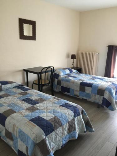 a room with two beds and a table with a table at Le Signoret in Sault-de-Vaucluse