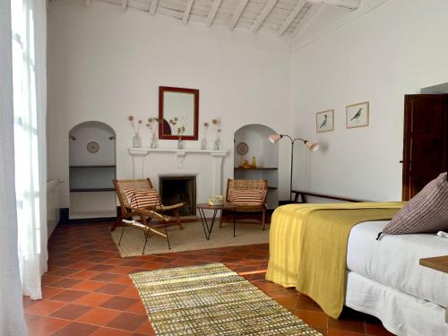 a white bedroom with a bed and a fireplace at Finca El Azahar in Trujillo