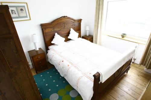 ニューリンにあるTrawler Cottage traditional cottage with stunning sea viewのベッドルーム1室(白いシーツ付きのベッド1台、窓付)