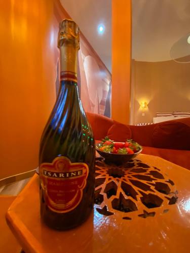 - une bouteille de bière sur une table avec un bol de salade dans l'établissement L'enveloppe Romantique, à Amiens