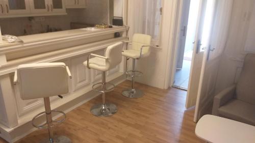 a room with three bar chairs and a mirror at Karpatia Vendeghaz 1201 Budapest in Budapest