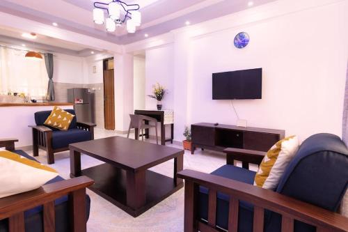 a living room filled with furniture and a flat screen tv at Levi's 1 Bedroom Apartment California Plaza Nanyuki in Nanyuki