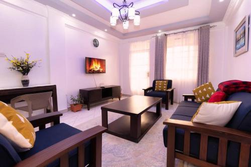 a living room with a couch and a table at Levi's 1 Bedroom Apartment California Plaza Nanyuki in Nanyuki