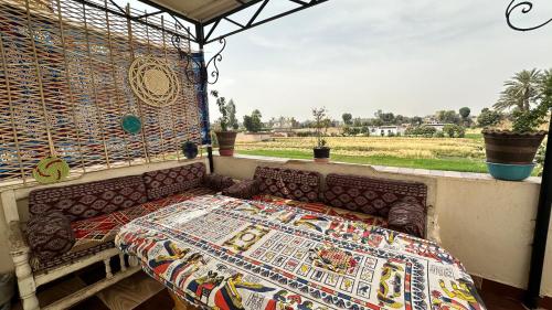 a bed on a balcony with a view of a field at Pharaonicas in Al Aqālitah
