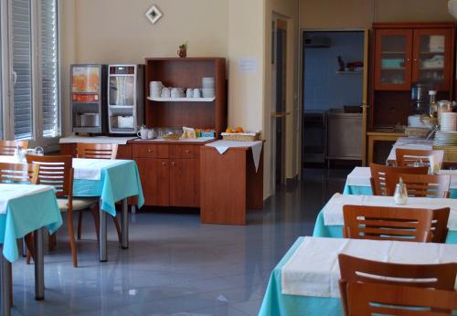 een restaurant met tafels en stoelen en een keuken bij Bed and Breakfast Kogoj in Nova Gorica
