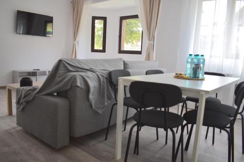 a living room with a couch and a table and chairs at Cosy&Minimalistic Apartments - Haret Building in Sinaia