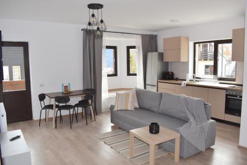 - un salon avec un canapé et une table dans l'établissement Cosy&Minimalistic Apartments - Haret Building, à Sinaia