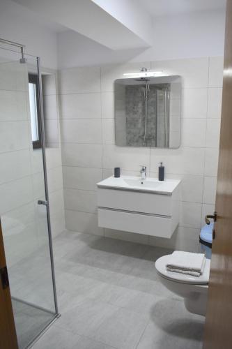 a white bathroom with a sink and a toilet at Cosy&Minimalistic Apartments - Haret Building in Sinaia