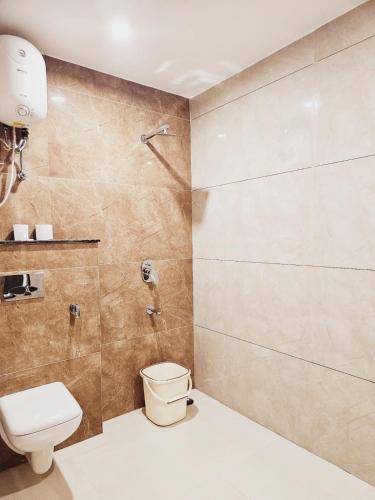 a bathroom with a toilet and a shower at Amahi Inn - Sector 48 in Gurgaon