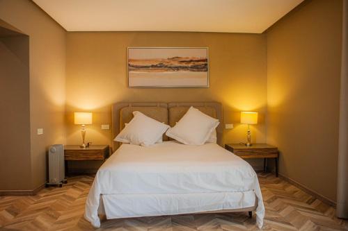 Appartement Marina في الدار البيضاء: غرفة نوم بسرير ابيض ومصباحين