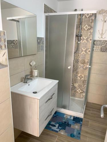 y baño con lavabo y ducha. en Victoria apartments en Lampedusa