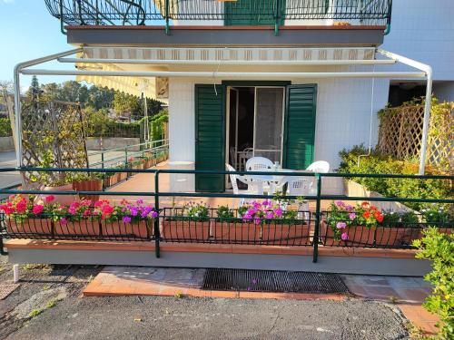 a house with a balcony with flowers on it at Sea Garden, fronte mare con piscina in Mascali