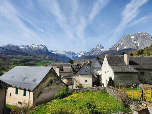 un village avec des montagnes enneigées en arrière-plan dans l'établissement Magnifique Cottage à Lescun, à Lescun