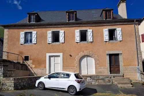 a white car parked in front of a house at Magnifique Cottage à Lescun in Lescun