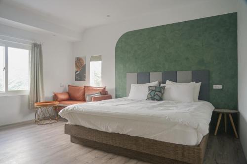 um quarto com uma cama grande e uma parede verde em Gegbyan em Ch'ia-la
