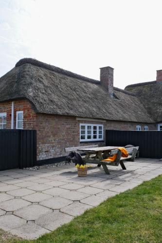 a picnic table in front of a brick building at Strandfogedgården in Ulfborg