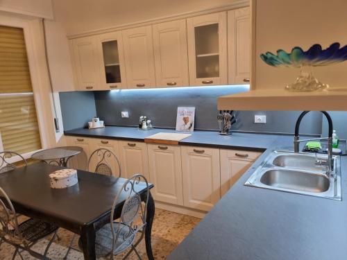 een keuken met een spoelbak en een tafel met stoelen bij La perle Marine in Diano Marina