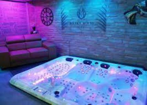 a room with a hot tub in a room with a couch at La Bohème in Paissy