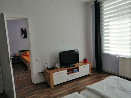 ein Wohnzimmer mit einem Flachbild-TV auf einem Schrank in der Unterkunft Violet House in Turda