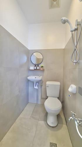 a bathroom with a white toilet and a sink at NEW Modern Suite near Beach & Airport in Sudtungan