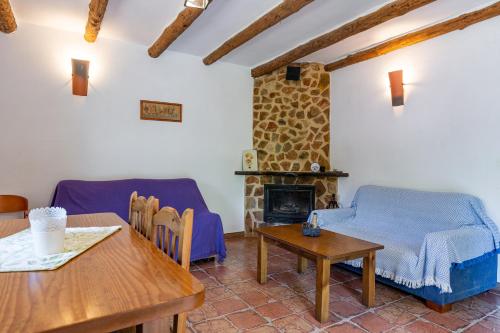 a living room with a table and a fireplace at Complejo Rural Rio Tus in Yeste