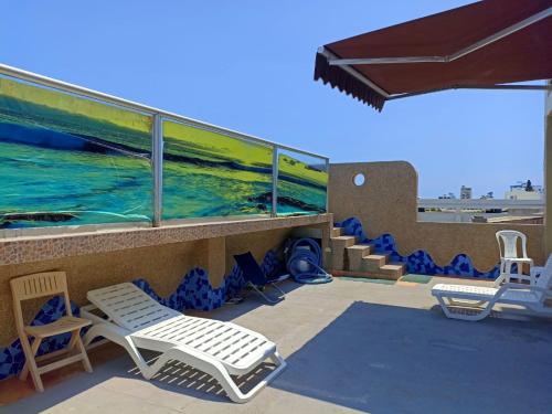 un patio con sillas y un balcón con vistas al océano. en HOTEL MARLUZ en Salinas