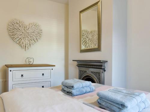 1 dormitorio con 2 toallas en una cama con chimenea en Sandend en Lytham St Annes