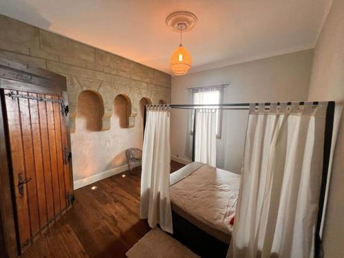 a bedroom with a bed with a curtain and a window at Cabana & Nuit de Château au bord du Lac Léman in Lugrin