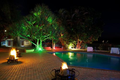 a swimming pool at night with lights around it at Destiny Lodge in White River
