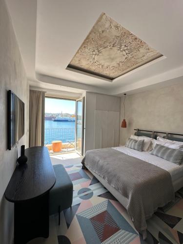 a bedroom with a bed and a view of the water at Kratísti in Ermoupoli