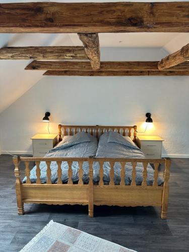 - une chambre avec un lit en bois et 2 lampes dans l'établissement Attic Room, à Korsør