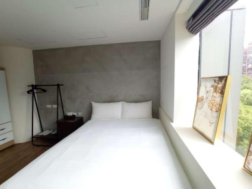 a white bed in a room with a large window at Happiness meworld in Taipei
