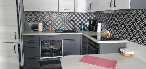 a kitchen with white cabinets and a black and white wallpaper at Ferienwohnung-Vogl in Viechtach