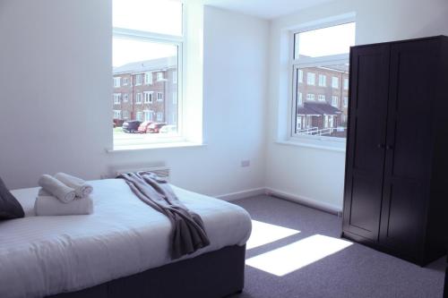 a bedroom with a bed and two windows at Cosy 1Bed Apartment in Heywood with Free Parking in Heywood