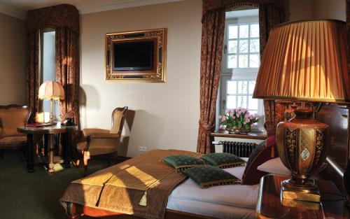 a bedroom with a bed with a lamp and windows at Zespół Pałacowy Pacółtowo na wyłączność in Pacółtowo