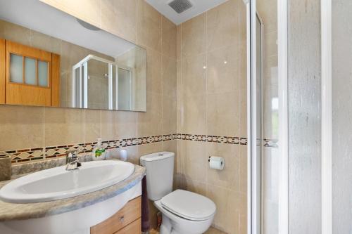 Un baño con inodoro, lavabo y ducha. en CB Living- Spacious sea view duplex with private jacuzzi, en Orihuela Costa