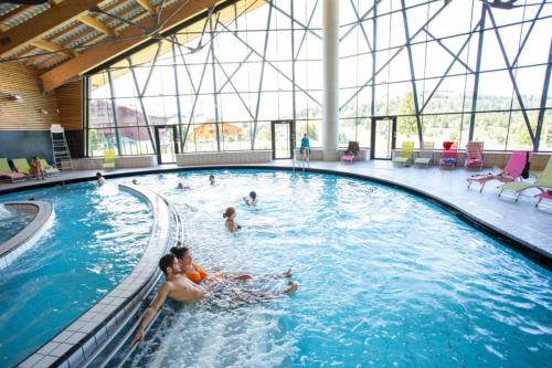 a group of people swimming in a swimming pool at Appartement 5 personnes Crest-Voland Espace Diamant in Cohennoz