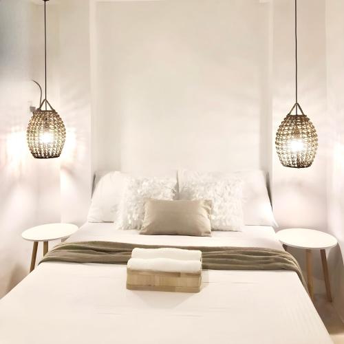 a white bedroom with a large bed with two tables at NEW Modern Suite near Beach & Airport in Sudtungan