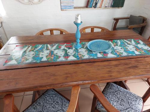 a wooden table with a plate and a candle on it at Lieflappie❤ in Stilbaai