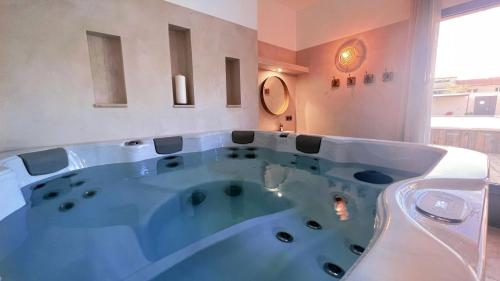 a large bath tub in a room with a window at Les Logis de Cocagne in Saint-Rémy-de-Provence