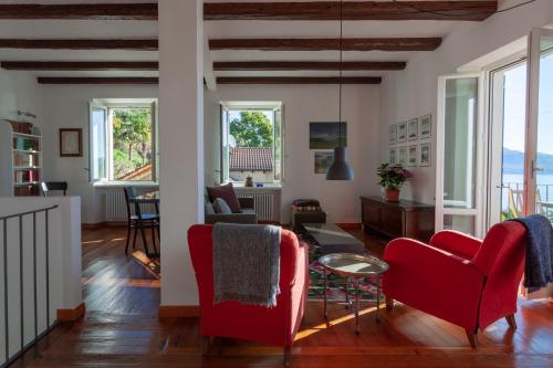 ein Wohnzimmer mit roten Stühlen und einem Tisch in der Unterkunft Cadebei in Oggebbio